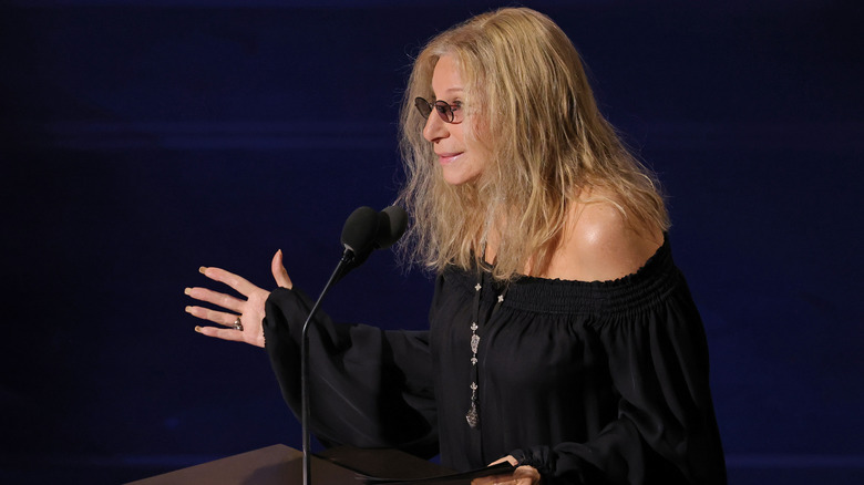 Barbra Streisand faisant des gestes vers un podium sur scène lors des Oscars 2026