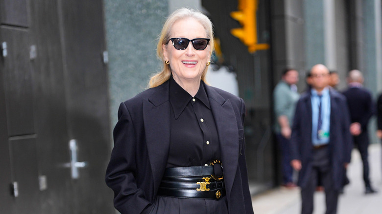 Meryl Streep portant du noir et des lunettes de soleil dans une rue de la ville