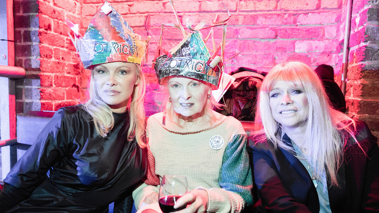 Pamela Anderson assise aux côtés de Vivienne Westwood et Jo Wood tout en portant une couronne d'aspect fait main