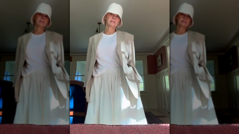 Photo de Pamela Anderson exhibant une tenue blanche légère et un chapeau de style cloche