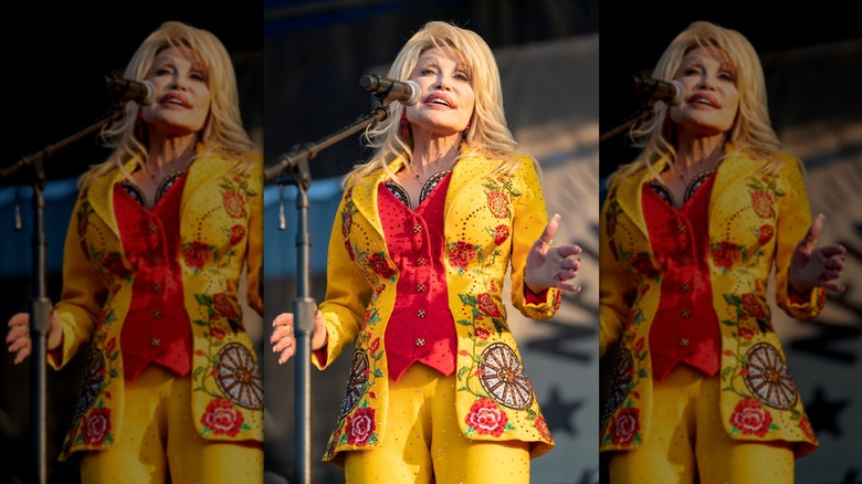 Dolly Parton sur scène dans un costume brodé jaune et rouge