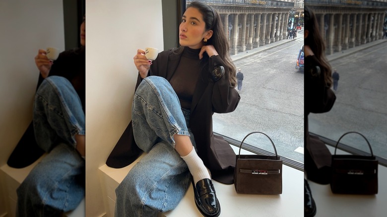 Une femme à une fenêtre portant des mocassins avec un jean