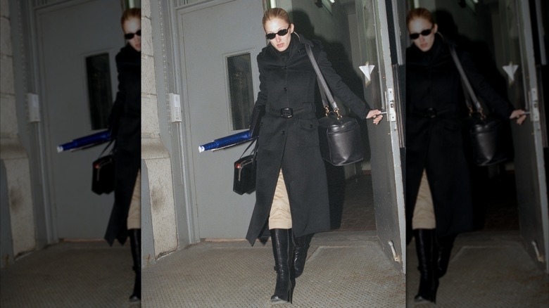 Carolyn Bessette Kennedy dans un manteau noir et des bottes à talons noires à New York