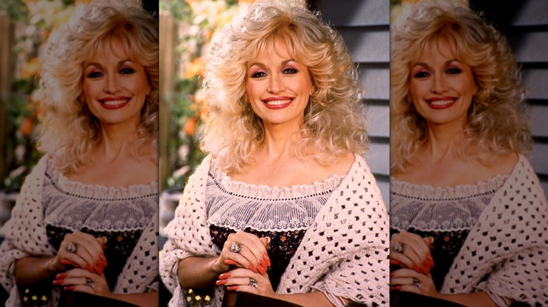 Dolly Parton dans une robe à froufrous avec de longs ongles rouges