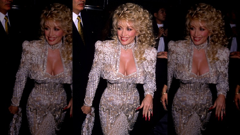 Dolly Parton sur le tapis rouge dans une robe blanche ornée de bijoux