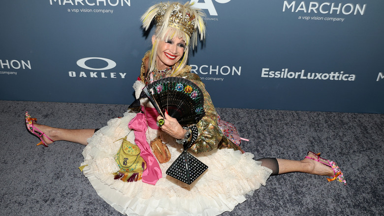 Betsey Johnson fait le grand écart sur le tapis rouge dans une jupe en tulle avec des accessoires colorés