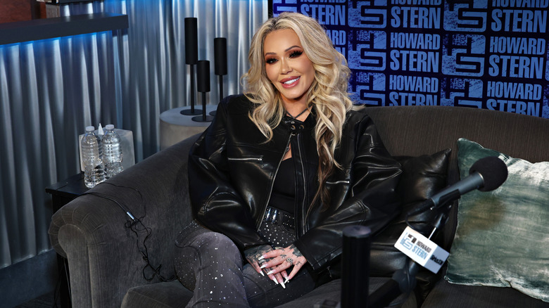 Bunnie Xo assis dans un studio d'enregistrement et portant une veste en cuir