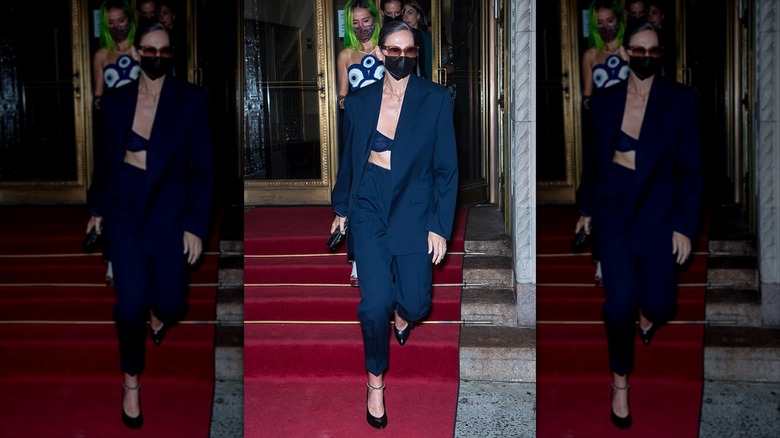 Jenna Lyons marche avec un masque et un costume trois pièces bleu marine