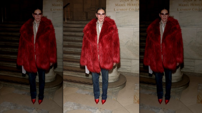 Jenna Lyons pose avec un jean et un manteau de fourrure rouge