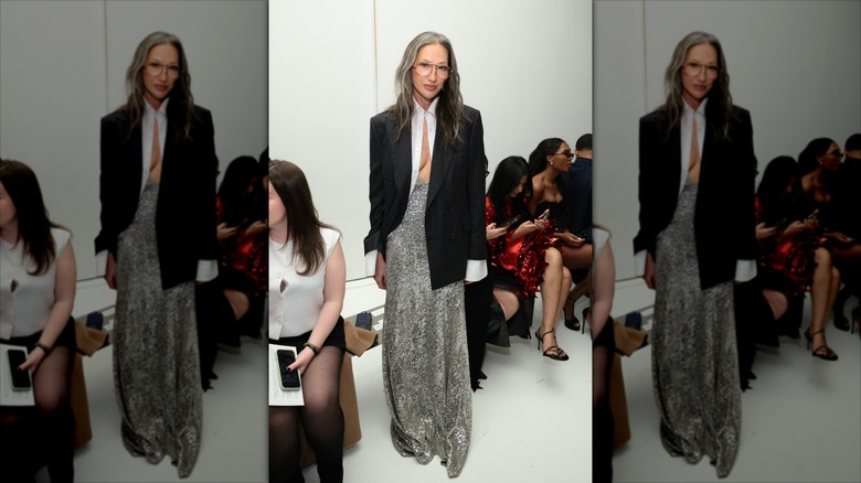 Jenna Lyons pose portant une chemise blanche, un blazer noir et une jupe longue à sequins argentés.