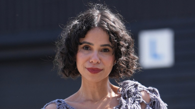 Une femme à l’expression neutre et au carré bouclé