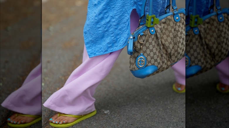 femmes marchant dans un pantalon violet avec des tongs vertes et des orteils bleus