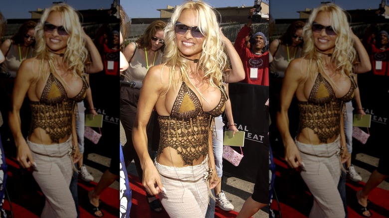 Pamela Anderson sourit en portant un haut marron au crochet et des lunettes de soleil