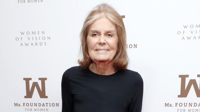 Gloria Steinem posant sur le tapis rouge devant un fond blanc
