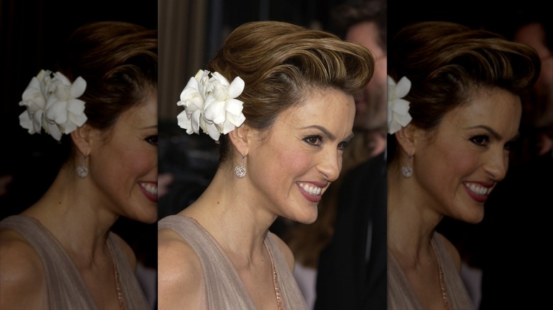 Mariska Hargitay portant une robe beige clair et une grande fleur blanche dans les cheveux