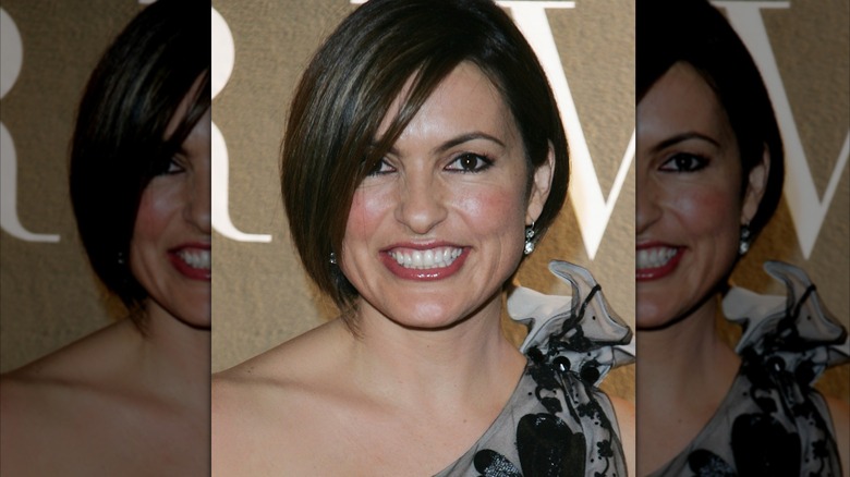 Mariska Hargitay portant une boucle d'oreille argentée et une robe à fleurs grise et noire
