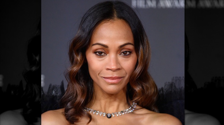 Zoe Saldana sourit sur le tapis rouge en 2025