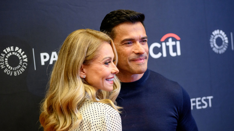 Kelly Ripa dans une robe blanche à pois et Mark Consuelo portaient un pull bleu