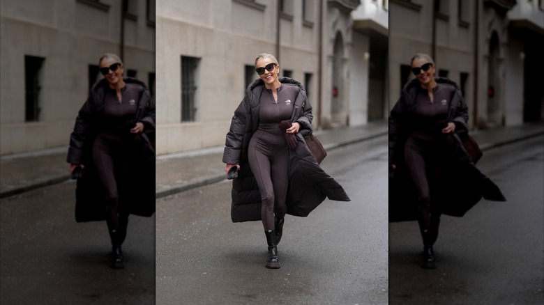 Une femme plus âgée marchant dans la rue vêtue de noir