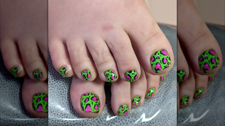 Une femme avec des orteils à imprimé animal rose fluo et vert