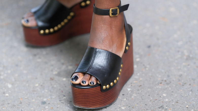 Femme portant des mules compensées nues