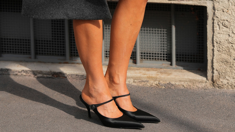 Femme portant des talons pointus noirs en résille et en cuir