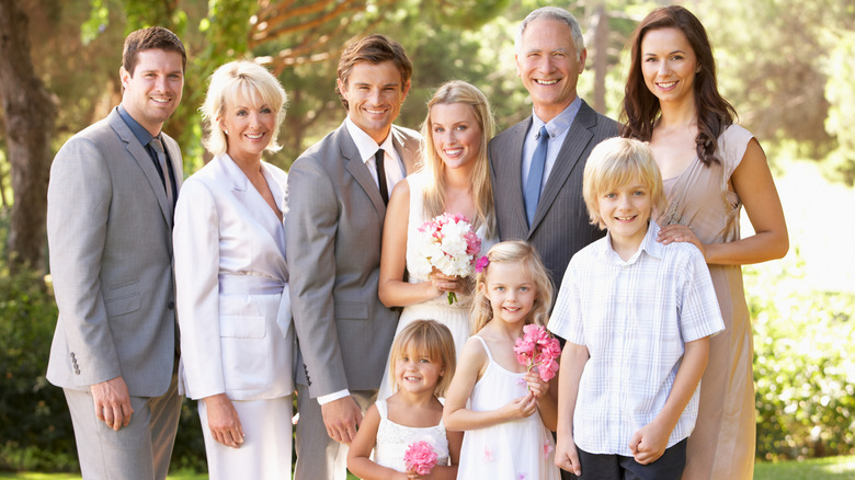 Une famille pose dehors pour un portrait de mariage