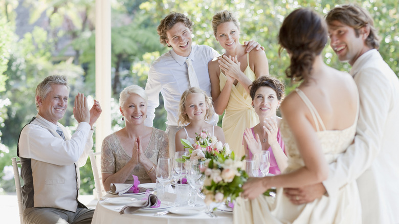 Une famille à table le jour d'un mariage