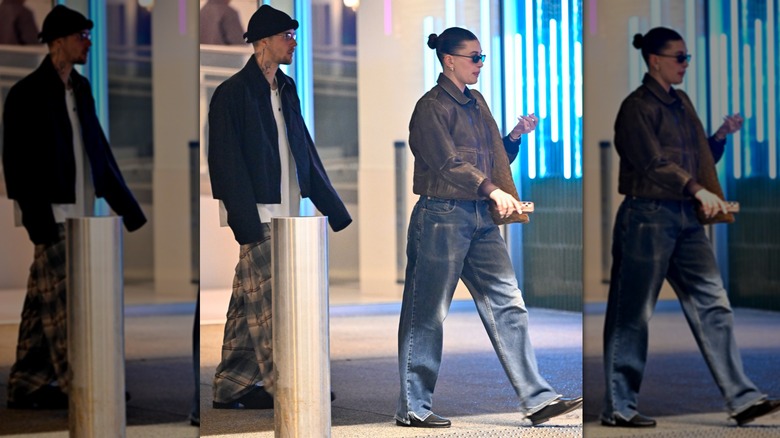 Hailey Bieber porte un jean bleu et un blouson aviateur marron et Justin Bieber porte un pantalon oversize à motifs