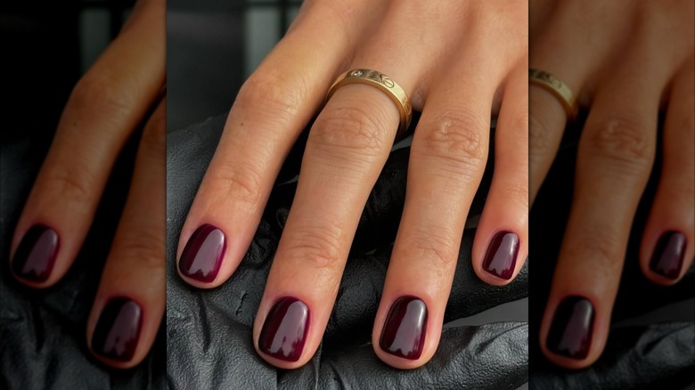 Un gros plan d'une femme avec du vernis à ongles merlot