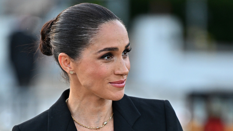 Un gros plan du visage de Meghan Markle où ses cheveux sont ramenés en chignon