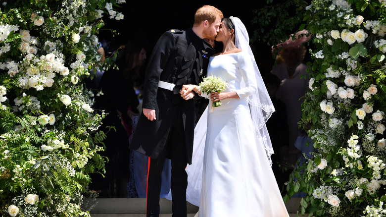 Le prince Harry embrasse Meghan Markle le jour de leur mariage, entouré de fleurs