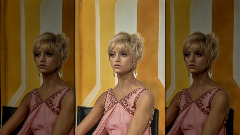 Goldie Hawn pose avec une coupe lutin et une robe rose