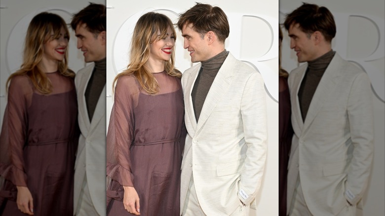 Suki Waterhouse et Robert Pattinson se sourient alors qu'ils se rapprochent pour prendre des photos