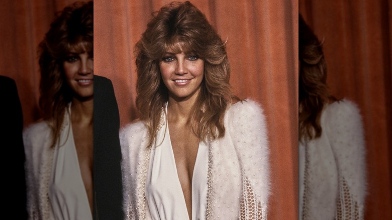 Heather Locklear souriante lors d'un événement des années 80 avec ses cheveux coiffés en plumes