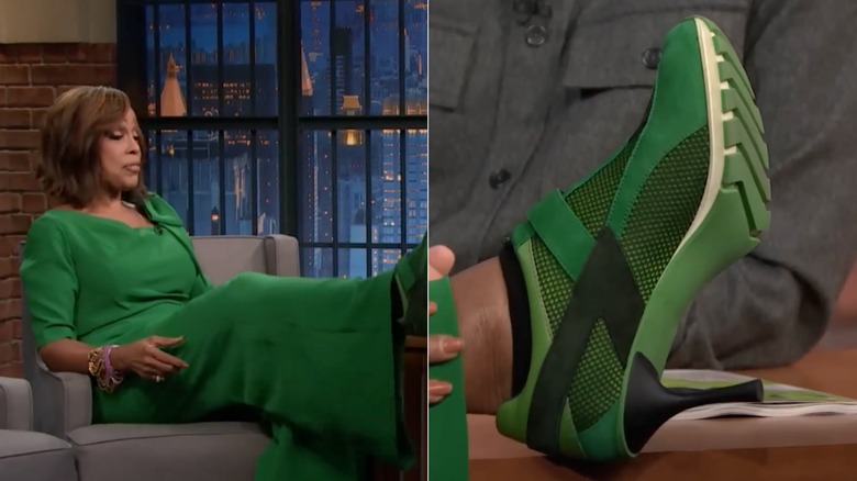 Gayle King pose ses pieds sur un bureau vêtue d'un ensemble vert