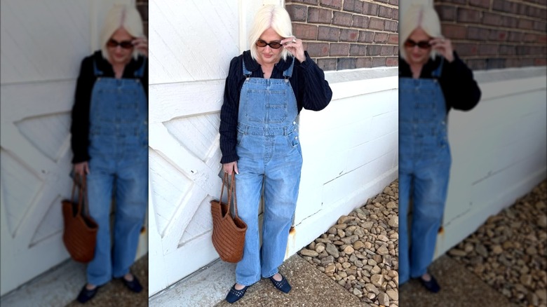 Une femme dans un pull bleu marine avec une salopette