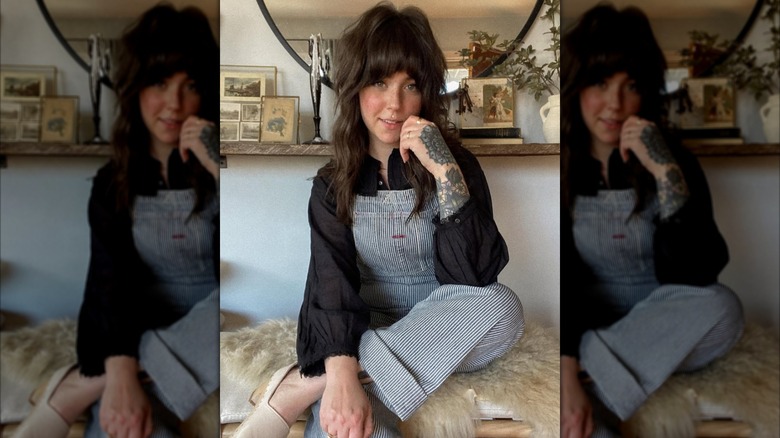 Une femme en salopette rayée avec une blouse paysanne noire