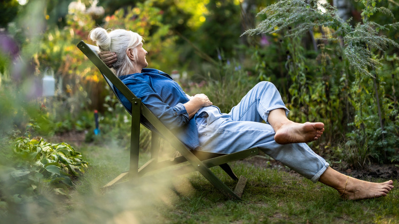 Femme plus âgée se prélassant dans son jardin