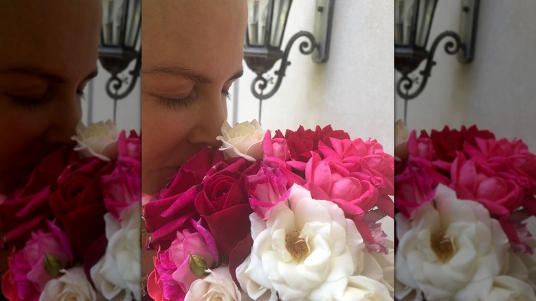 Gros plan de Nicole Kidman sentant un bouquet de roses roses, rouges et blanches