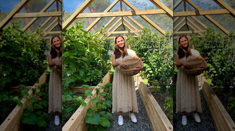 Jennifer Garner debout dans sa maison de jardin tout en tenant un panier en bois