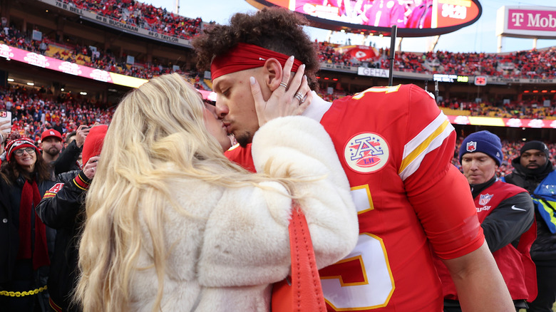 Brittany Mahomes embrasse Patrick Mahomes sur le terrain de football