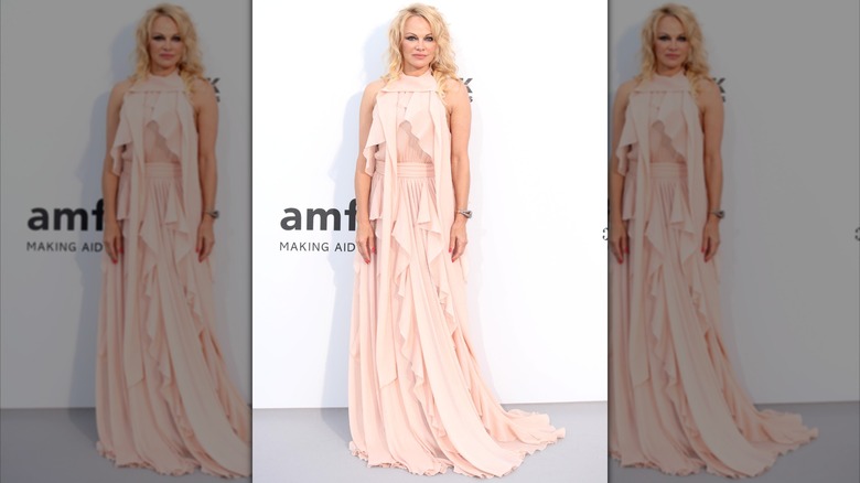 Pamela Anderson dans une robe pêche avec de longues bandes de tissu