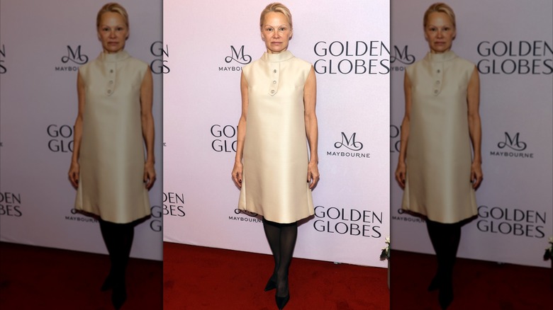 Pamela Anderson dans une robe crème avec des collants noirs