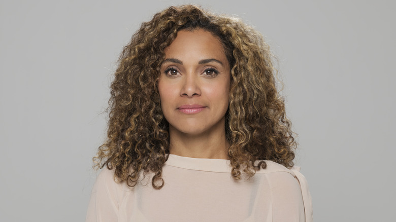 Femme aux yeux marron clair et aux cheveux blond caramel