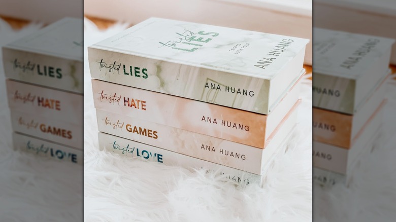Les livres de la série Twisted empilés sur un tissu blanc pelucheux