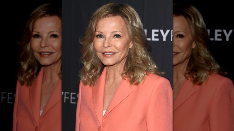 Gros plan de Cheryl Ladd debout, inclinée, souriante et portant des lèvres couleur pêche.