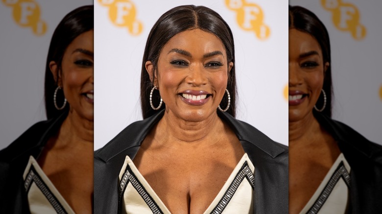 Gros plan d'Angela Bassett, souriante tout en portant un rouge à lèvres brillant aux tons baies lors d'un événement BFI