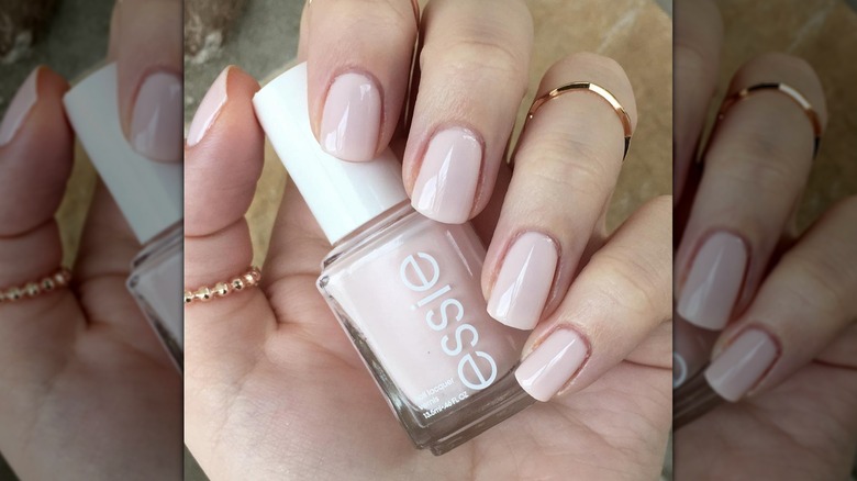 Gros plan des mains d'une personne avec des chaussons de ballet Essie peints sur ses ongles.