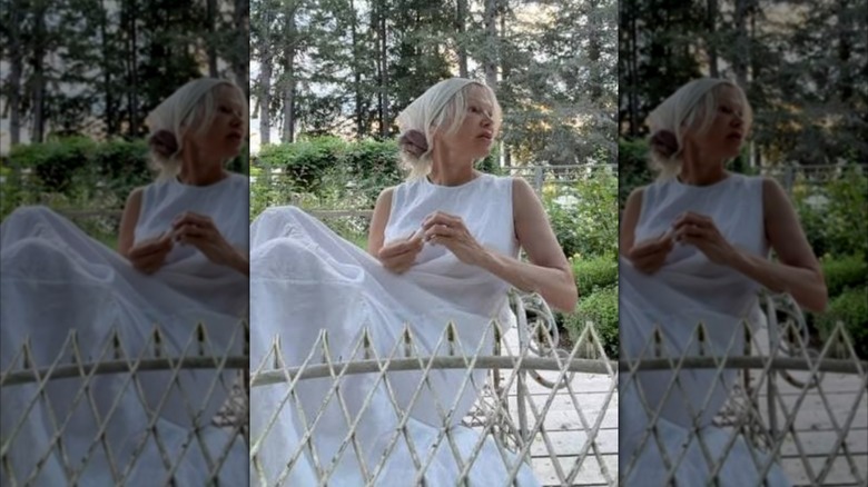 Pamela Anderson assise sur une terrasse